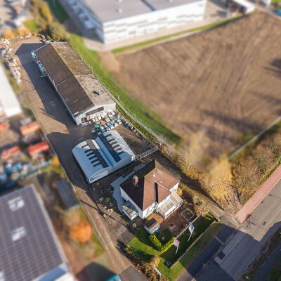 Blick von weit oben auf ein Gelände mit Lagergebäuden und einem Haus