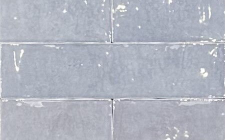grau glänzende, unebene, längliche Wandfliesen, Nahaufnahme