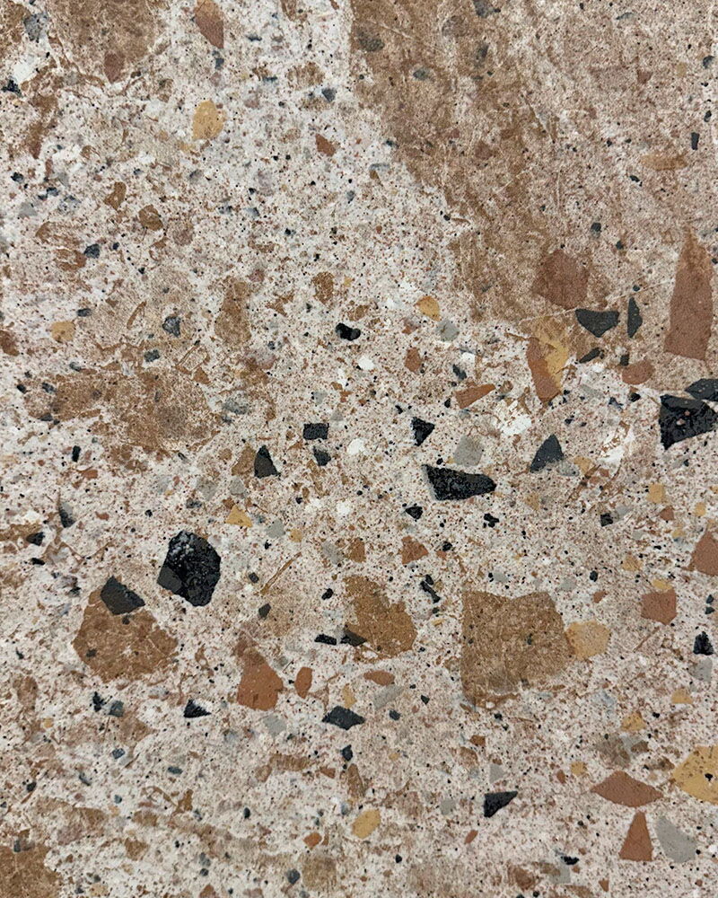 Nahaufnahme einer braun-beige gesprenkelten Fliese in Terrazzo-Optik