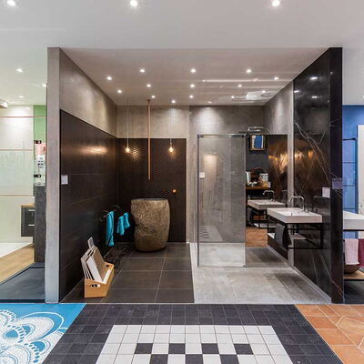 Ausstellungsraum mit Badewanne, mehreren Waschbecken mit Untertischen sowie verschiedenen Wand- und Bodenfliesen