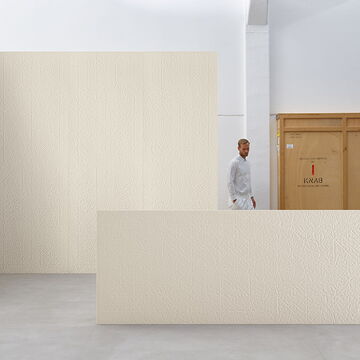 sehr große Designerfliesen Folded XL; dahinter steht ein Mann, der erst ab der Hüfte zu sehen ist; im Hintergrund eine Wand mit der gleichen Fliese