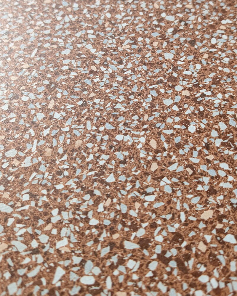 Nahaufnahme einer rot-weiß-schwarz gesprenkelten Fliese in Terrazzo-Optik