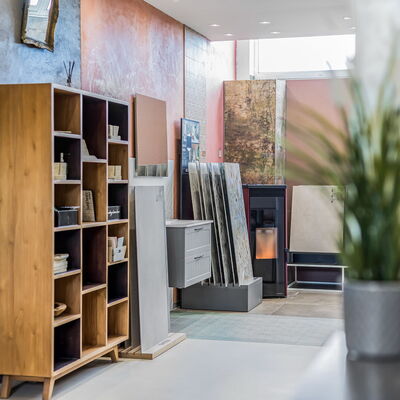unterschiedlich gestaltete Wände im Ausstellungsraum, im Vordergrund ein Holzregal mit Musterfliesen