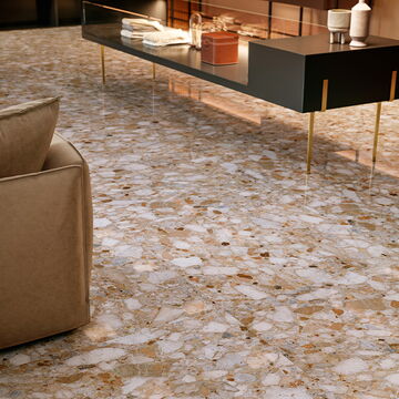 Rot-weiß-grau-beige gesprenkelte Fliese in Terrazzo-Optik mit Möbeln im Raum
