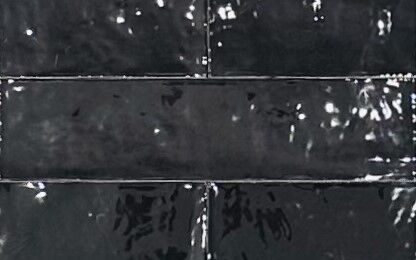 schwarz glänzende, unebene, längliche Wandfliesen, Nahaufnahme