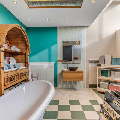 Fliesenaustellung mit Badewanne und altem Holzregal, in dem verschiedenen Fliesen präsentiert werden