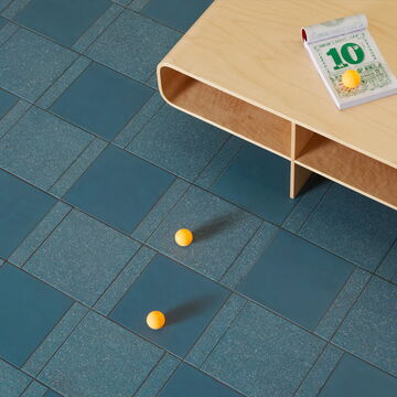 Zwei Tischtennisbälle und ein Tisch stehen auf der Mutina Designerfliese Time